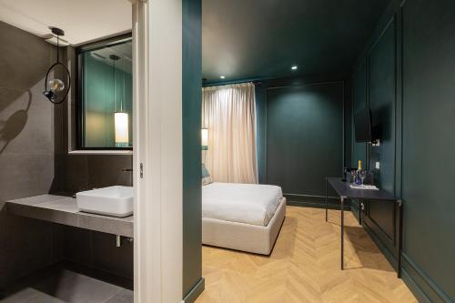 a bedroom with a bed and a sink and a mirror at The Mendeli Suite in Rome