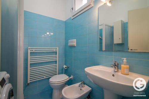 a blue bathroom with a sink and a toilet at YPApartments FIERA in Padova
