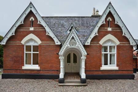 a red brick building with two windows and a door at Garden Double Room with own door access and bathroom in Rostrevor