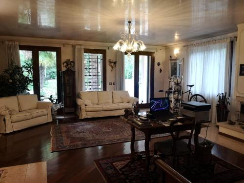 sala de estar con sofás, mesa y lámpara de araña en La Casa Sull'Albero, en Mestre