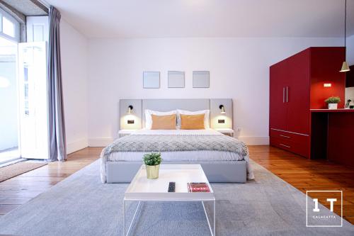 a white bedroom with a bed and a table at Calacatta Housing in Porto