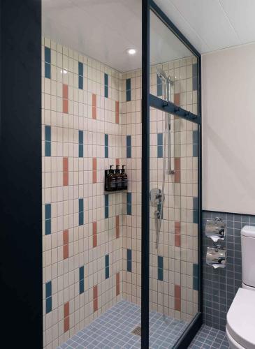 a bathroom with a glass shower with a toilet at Eaton HK in Hong Kong