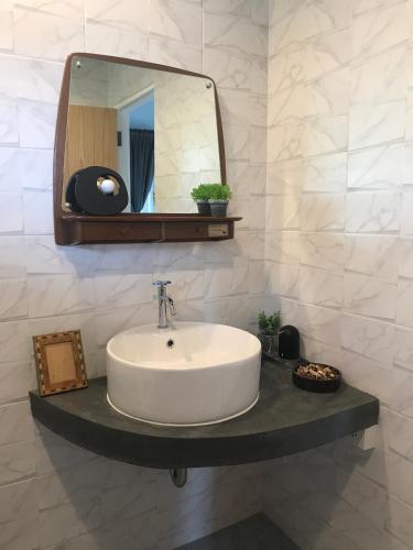 a bathroom with a sink and a mirror at P.O.E Posh Homestay in Cha Am
