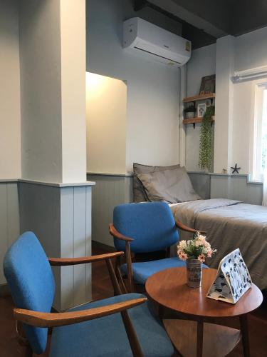 a room with two chairs and a table and a bed at P.O.E Posh Homestay in Cha Am