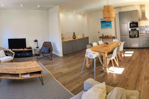 een woonkamer met een tafel en een keuken bij Maison de ville en plein cœur de Sanary 3 double chambres 105M2 in Sanary-sur-Mer