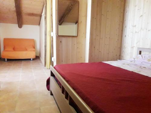 Giunganoにあるcasa vacanza San Feliceのベッドルーム1室(ベッド1台、オレンジの椅子付)