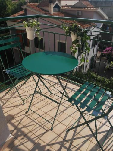 a green table and a chair on a patio at Via Stazione 5 in Praia a Mare