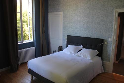 a bed with white sheets and pillows in a bedroom at CLOS MARIE in Iguerande