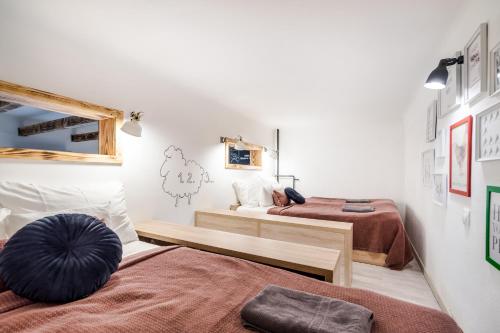 two beds in a room with white walls at Own Budapest at Gozsdu in Budapest