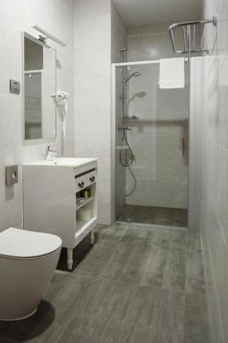 a bathroom with a shower and a toilet and a sink at New Era Hotel Old Town Bucharest- parking with fee nearby - NOT at the hotel ! in Bucharest