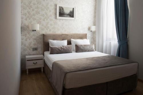 a bedroom with a bed and a window at New Era Hotel Old Town Bucharest- parking with fee nearby - NOT at the hotel ! in Bucharest