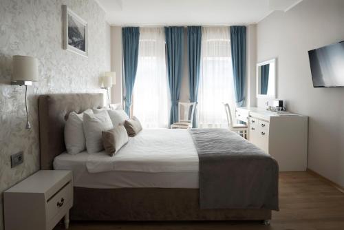 a hotel room with a bed and a table and chairs at New Era Hotel Old Town Bucharest- parking with fee nearby - NOT at the hotel ! in Bucharest
