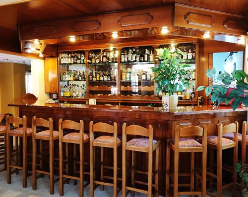 a bar with a bunch of bar stools at Titania Hotel Karpathos in Karpathos
