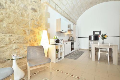 een keuken met een tafel en een stoel in een kamer bij ragusa curtigghiu in Ragusa