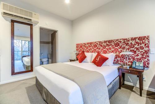 a bedroom with a large bed with a red headboard at Parkview On Hagley in Christchurch
