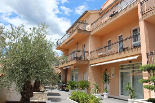 a building with balconies and trees in a courtyard at Apartments Villa Jelena in Vodice