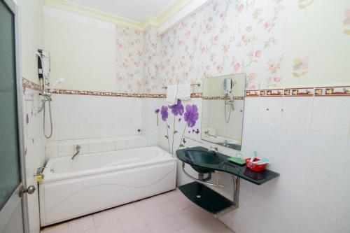 a bathroom with a tub and a sink and a mirror at Hung Dong Hotel in Quy Nhon