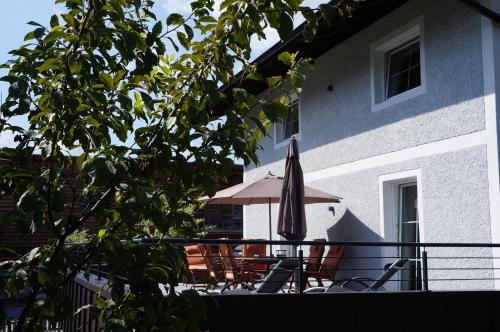 a patio with an umbrella and chairs on a balcony at MyApart Jochberg in Jochberg