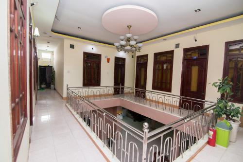 a corridor of a building with a staircase and a chandelier at Hung Dong Hotel in Quy Nhon