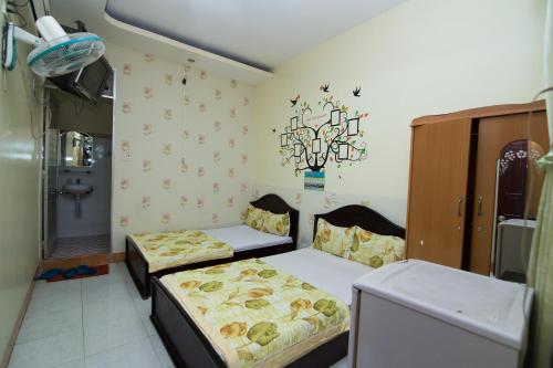 a small room with two beds and a chandelier at Hung Dong Hotel in Quy Nhon