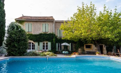 une maison avec une piscine devant une maison dans l'établissement Mas de l'arrivette, à Saint-Geniès-de-Comolas