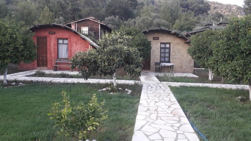 a house with a stone walkway in front of a yard at Simurg Evleri Olympos in Olympos