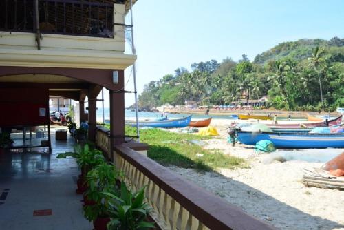 a group of boats on the beach next to a building at Baia Do Sol - Beach boutique in Baga