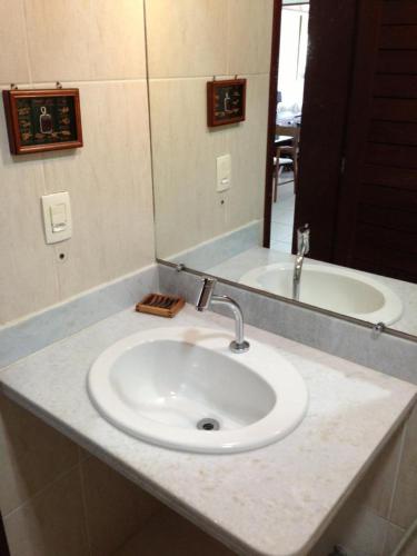 a bathroom counter with a sink and a mirror at Coco Beach Apart 5B in Natal