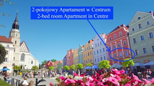a city street with pink flowers and buildings at Apartament Przy Starówce - Bella in Bolesławiec
