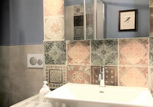 bagno con lavandino e specchio di THE BLUE LODGE-cozy flat close to Piazza del Campo a Siena