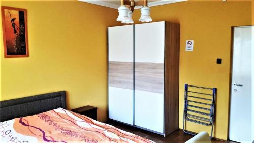 1 dormitorio con un gran armario blanco junto a una cama en Alex's Apartman & Panzió, en Hajdúszoboszló