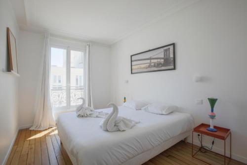 パリにあるJoie Paris TOUR EIFFEL - Rue Clerの白いベッドルーム(白鳥2羽のベッド付)