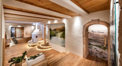 a living room with a large painting on the wall at Bar Garni Reischnhitt des Eschgfeller Christoph in Sarntal