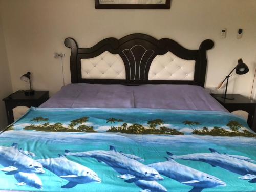 a bedroom with a bed with dolphins on it at My Ozi Perl New Creole Villas in Grand'Anse Praslin