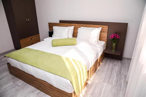 a bedroom with a large bed with a green pillow at Garden Inn Resort Sevan in Sevan