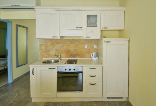 a kitchen with white cabinets and a sink at Kazanegra Exclusive Apartments in Sveti Stefan