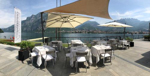 a restaurant with white tables and umbrellas on a patio at Casa Sull'Albero in Malgrate