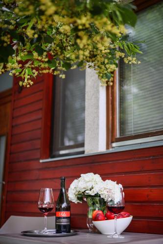 a table with two glasses of wine and a bowl of flowers at Barack Thermal & Natura Apartments in Tiszakécske