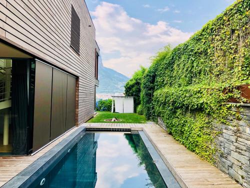 a house with a swimming pool next to a wall at Casa Sull'Albero in Malgrate