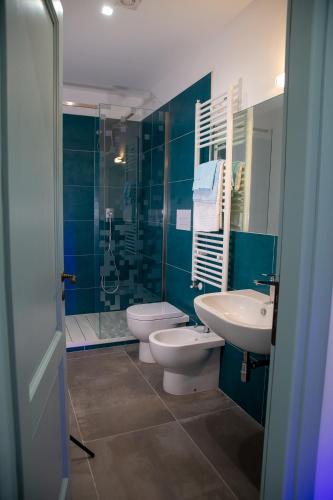 a bathroom with two toilets and a sink and a shower at La Casetta - Rooms & Garden in San Ferdinando