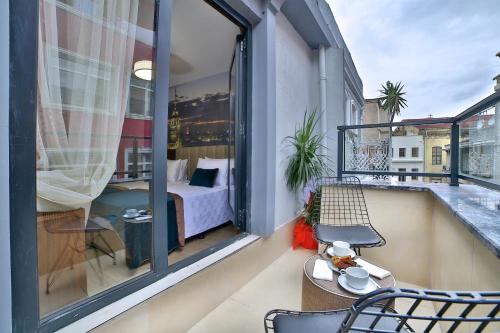 un balcone con letto e una camera con finestra di The Tango Hotel Taksim a Istanbul