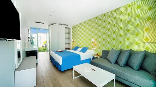 英格兰海滩Hotel Nayra - Adults Only的一间带床、沙发和电视的卧室