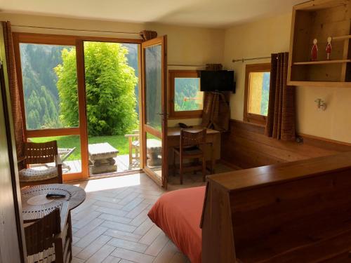 - une chambre avec une grande fenêtre et un bureau avec vue dans l'établissement Les Chalets du Villard, à Saint-Véran