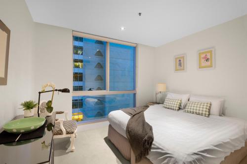 Un dormitorio con una cama grande y una ventana en StayCentral - Melbourne Central, en Melbourne