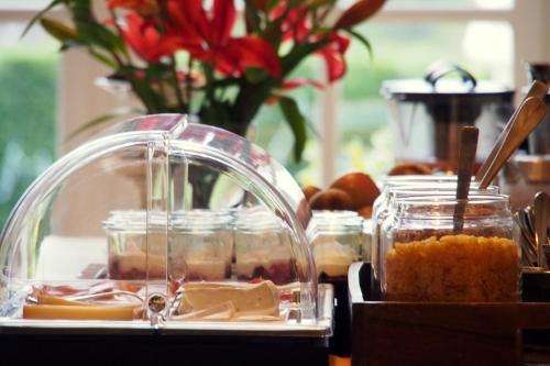 een tafel met potten voedsel en bloemen bij Hotel Le Moulin du Château in Saint-Laurent-du-Verdon