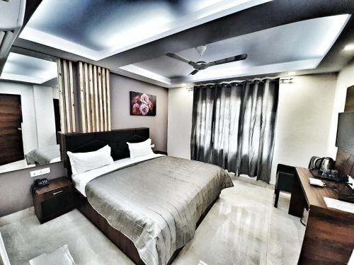 a bedroom with a large bed and a desk at Hotel Aerocity Purple Orchid in New Delhi