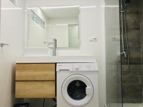 a bathroom with a washing machine and a sink at Tobago Happy Paradise in Puerto Rico de Gran Canaria