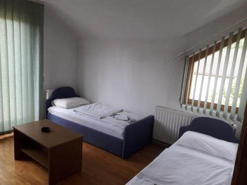 Šipovo的住宿－Motel Tetrijeb Sipovo，小房间设有两张床和一张桌子