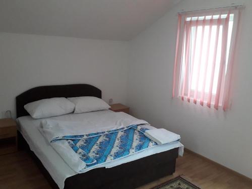 a bedroom with a bed with a black headboard and a window at Motel Tetrijeb Sipovo in Šipovo