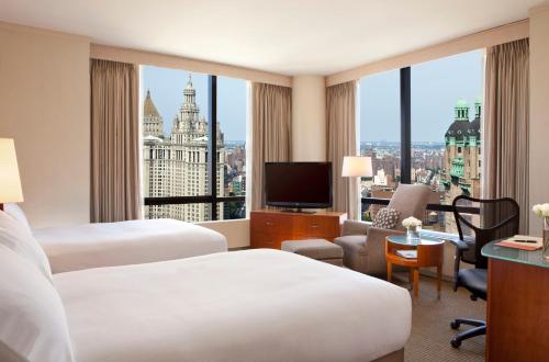 a hotel room with two beds and a view of the city at Millennium Downtown New York in New York